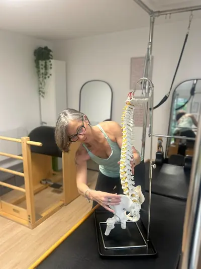 Liz Shaw, personal trainer and Pilates coach in Ealing, demonstrating spinal anatomy in her Willow Studio