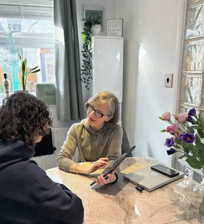 Liz Shaw wellness and nutrition coach in Ealing consulting with a client.